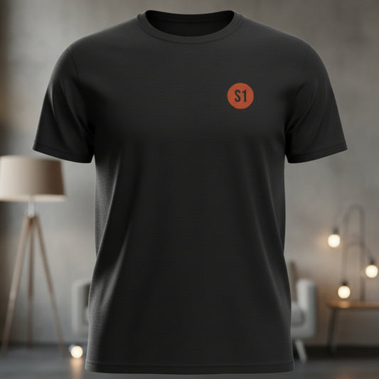 Vorderansicht des schwarzen Unisex T-Shirts im Regular Fit mit einem kleinen, orangefarbenen Status-1-Logo auf der linken Brust.