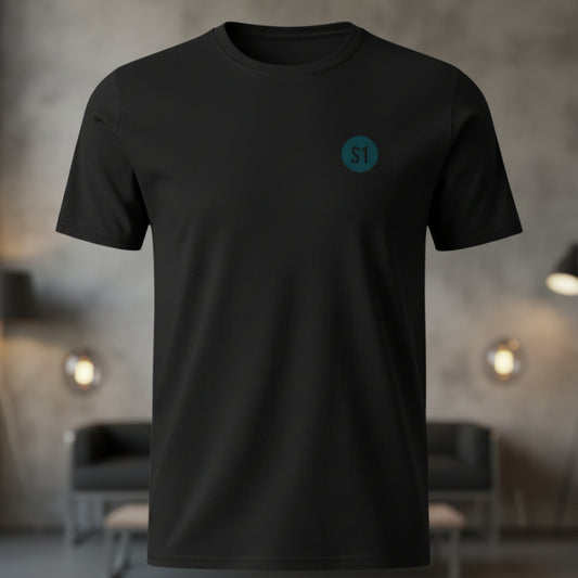 Vorderansicht des schwarzen Unisex T-Shirts im Regular Fit mit einem kleinen, blauen Status-1-Logo auf der linken Brust.