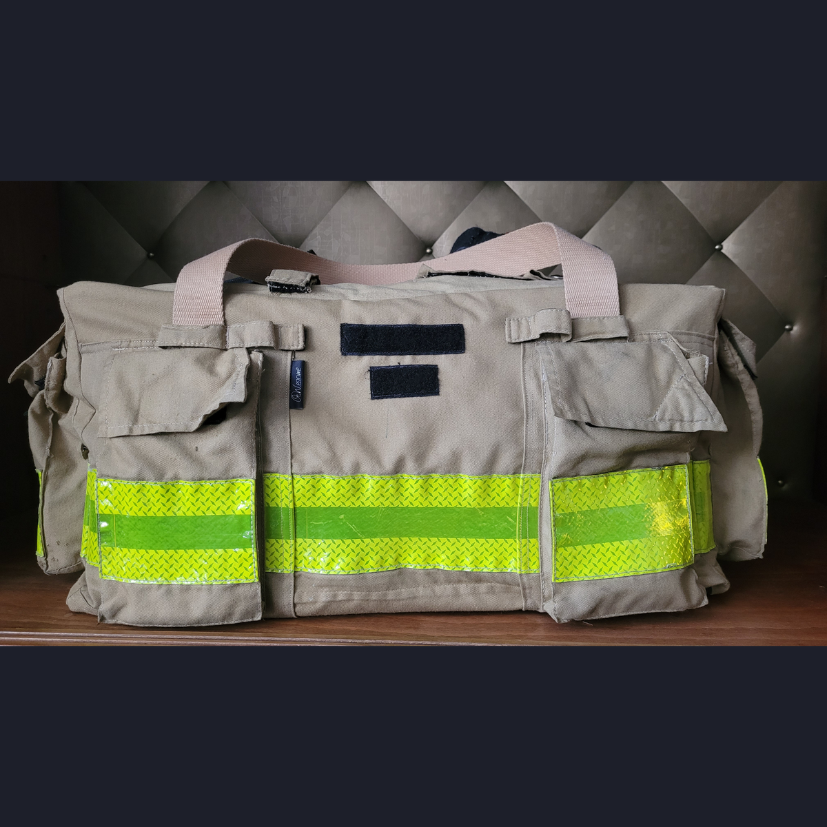 Upcycling-Feuerwehrtasche aus beiger Einsatzkleidung mit neongelben Reflektorstreifen, aufgesetzten Taschen und schwarzen Klettstreifen.