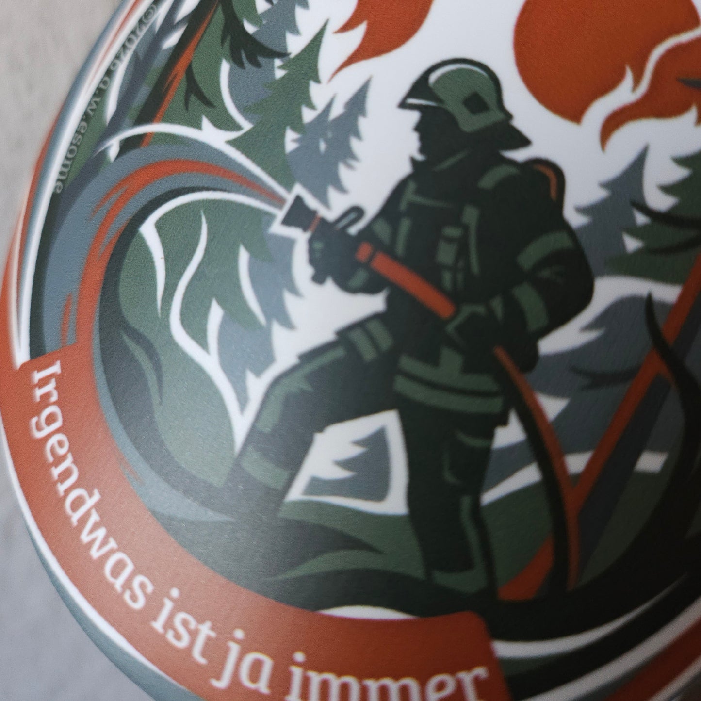Detail des Aufklebers Motiv Waldbrand mit einer Einsatzkraft beim Löschen eines Feuers im Wald mit dem Strahlrohr.
