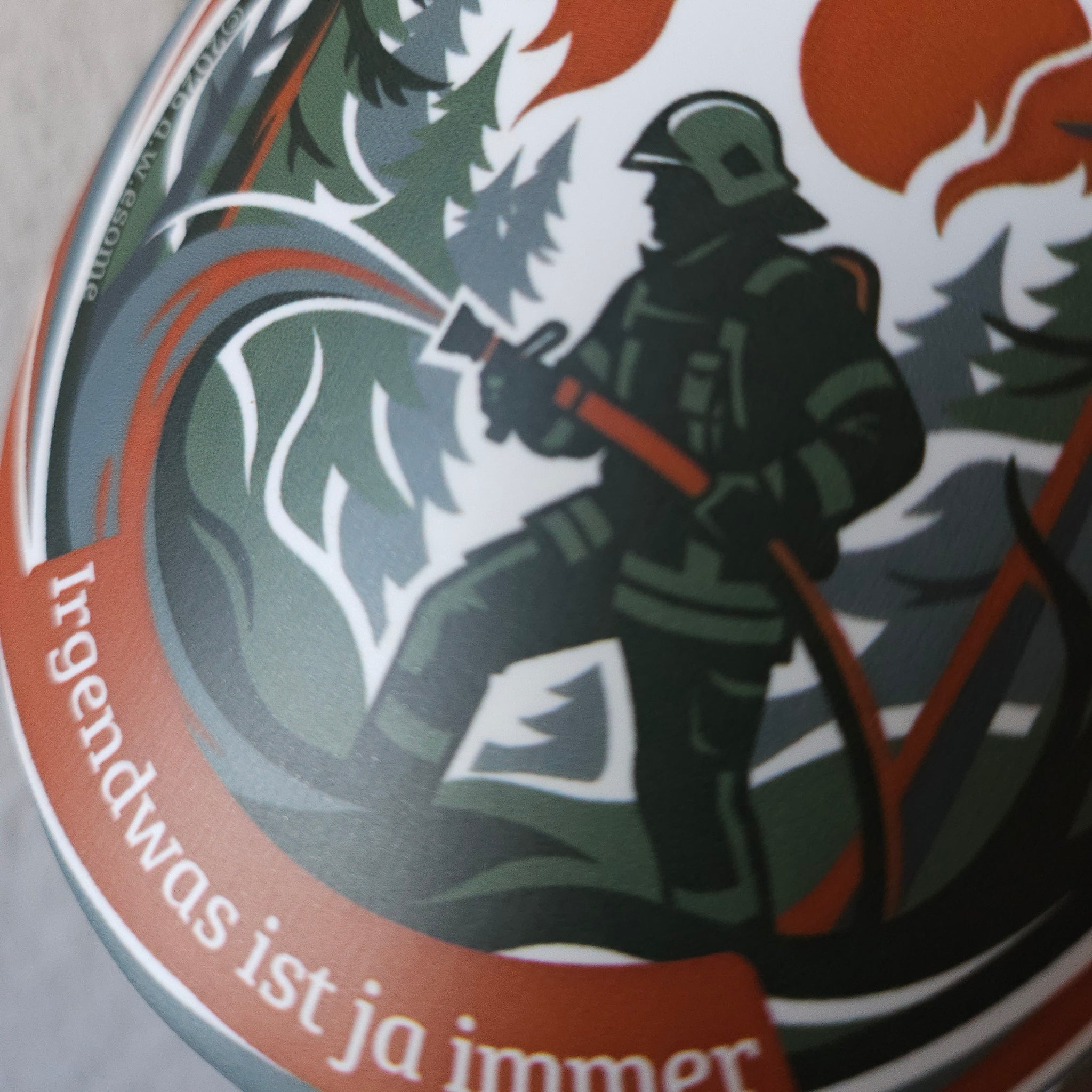 Detail des Aufklebers Motiv Waldbrand mit einer Einsatzkraft beim Löschen eines Feuers im Wald mit dem Strahlrohr.
