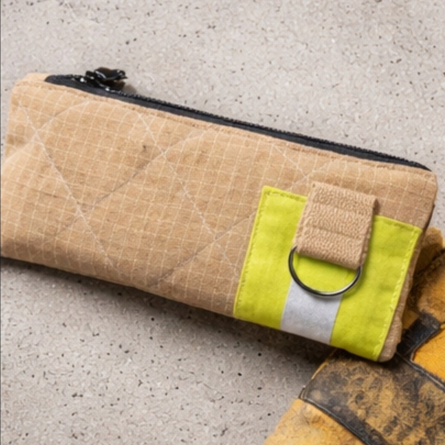 Beige Kulturtasche UNIT 112 aus strapazierfähigem Aramid-Einsatzstoff mit rautenförmiger Steppung und gelbem Reflektorband.