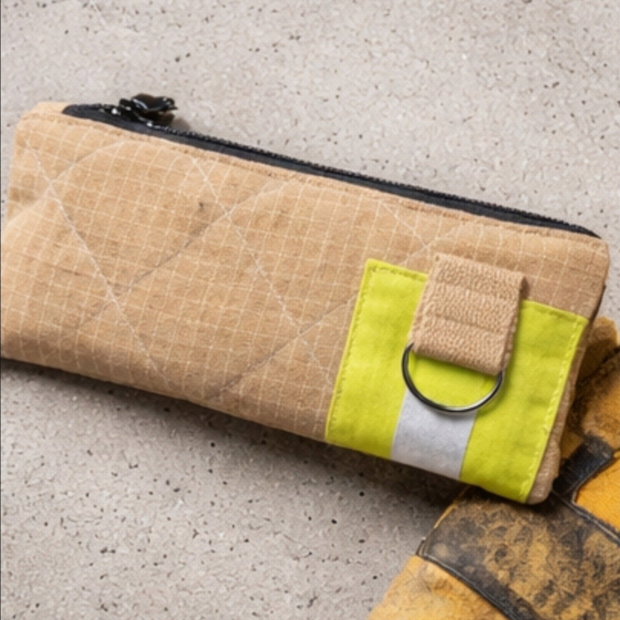 Beige Kulturtasche UNIT 112 aus strapazierfähigem Aramid-Einsatzstoff mit rautenförmiger Steppung und gelbem Reflektorband.