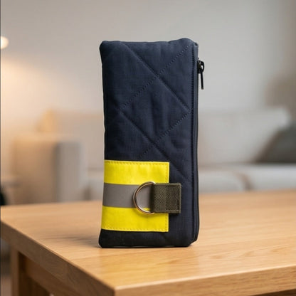 Kompaktes Schlampermäppchen aus Feuerwehrschlauch und schwarzem Stoff steht auf einem Couchtisch aus Holz im Wohnzimmer.