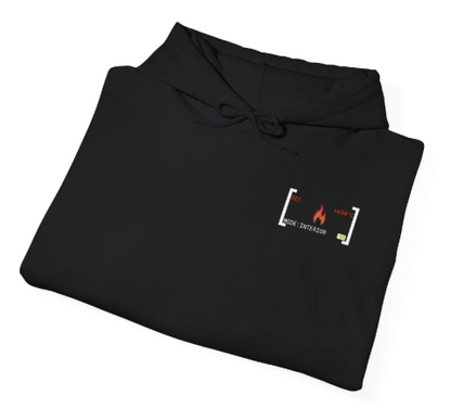Ordentlich zusammengefalteter schwarzer Feuerwehr-Hoodie auf Holzgrund, der das dezente Brustlogo im Detail zeigt.