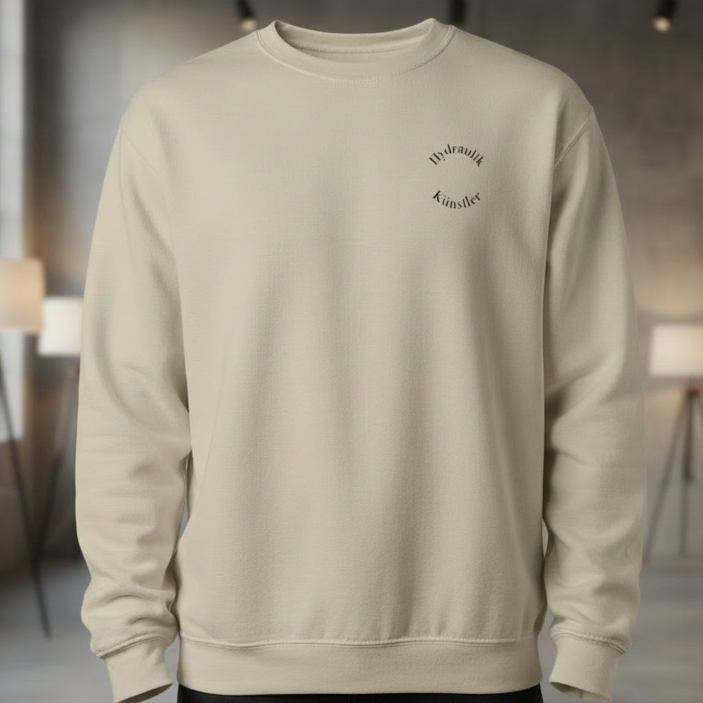 Vorderansicht des sandfarbenen Unisex-Pullovers im Regular Fit mit dem dezenten, runden Brust-Aufdruck Hydraulik Künstler.