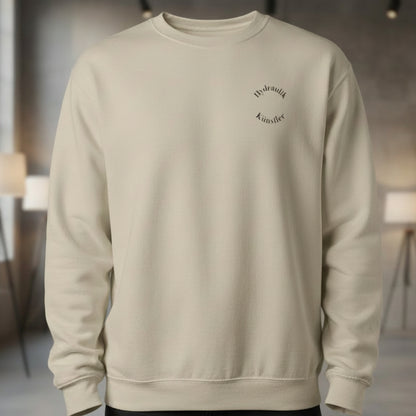 Vorderansicht des sandfarbenen Unisex-Pullovers im Regular Fit mit dem dezenten, runden Brust-Aufdruck Hydraulik Künstler.