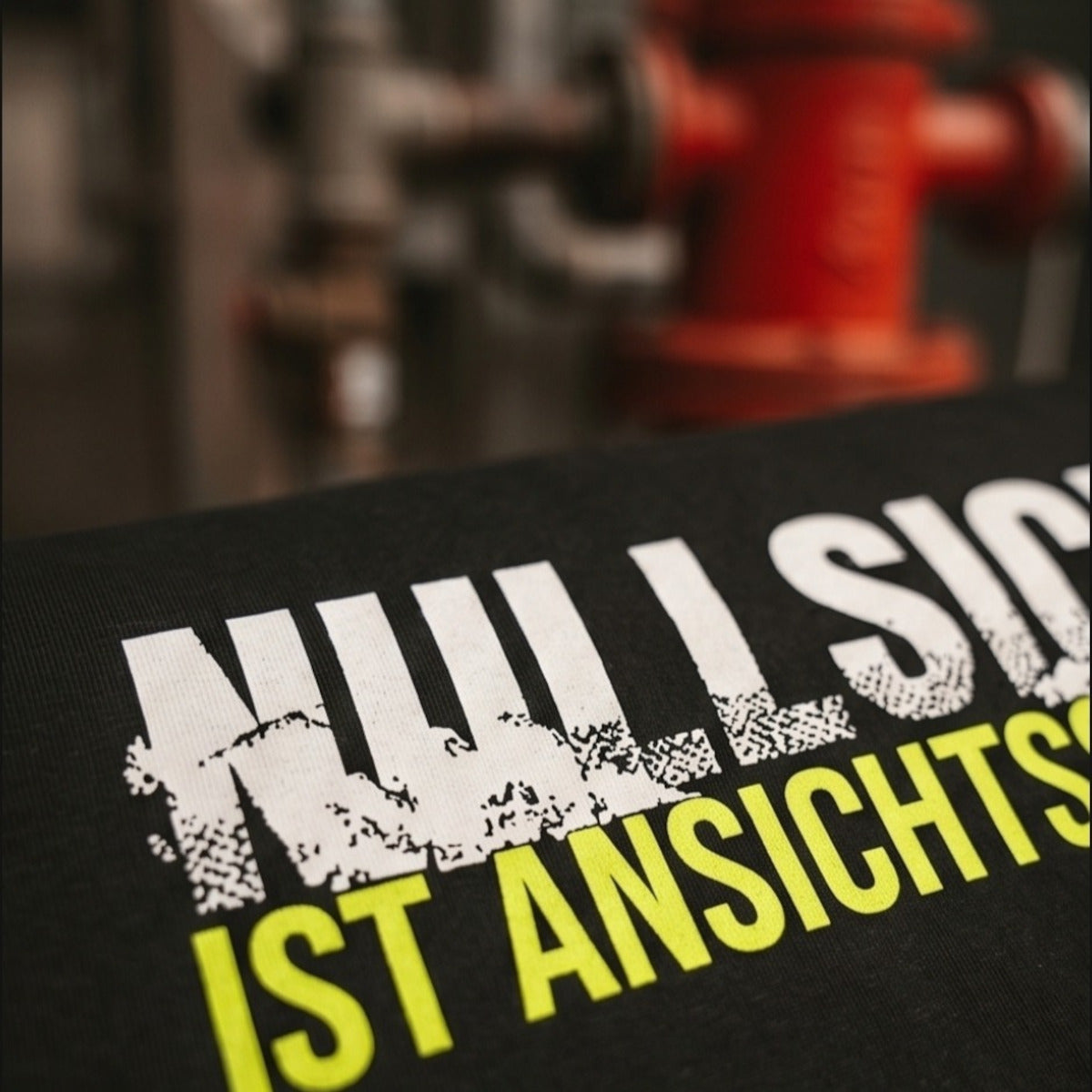 Detailansicht des hochwertigen Textaufdrucks Nullsicht Ist Ansichtssache im rauen Grunge-Look auf schwarzem Baumwollstoff.