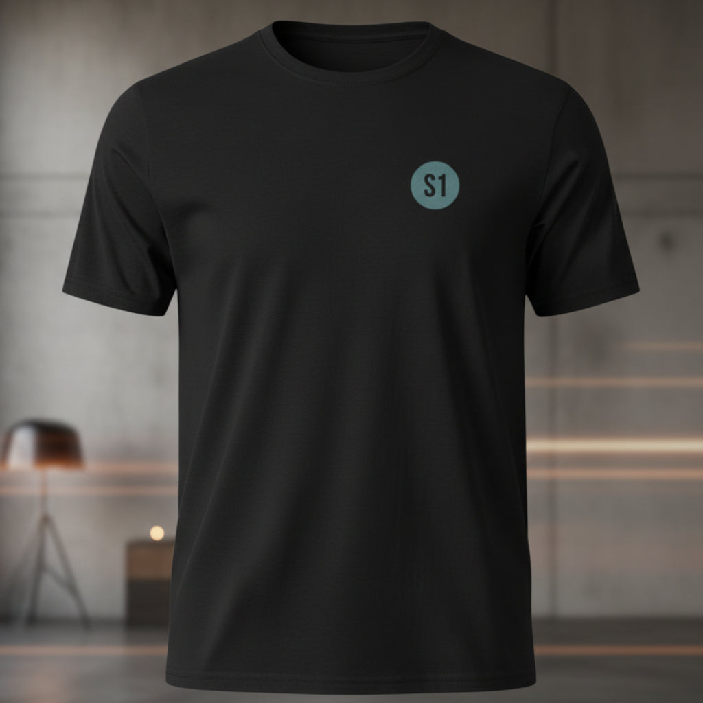 Vorderansicht des schwarzen Unisex T-Shirts im Regular Fit mit einem kleinen, blauen Status-1-Logo auf der linken Brust.