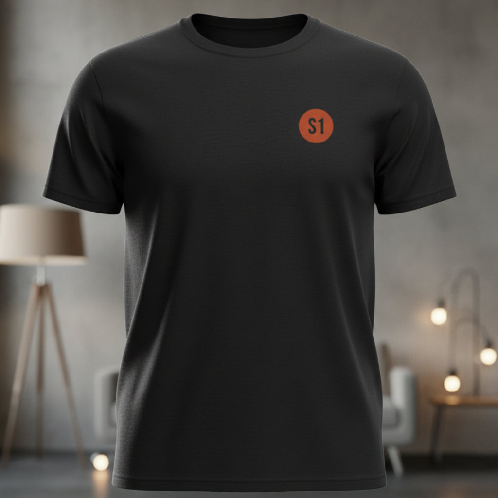 Vorderansicht des schwarzen Unisex T-Shirts im Regular Fit mit einem kleinen, orangefarbenen Status-1-Logo auf der linken Brust.
