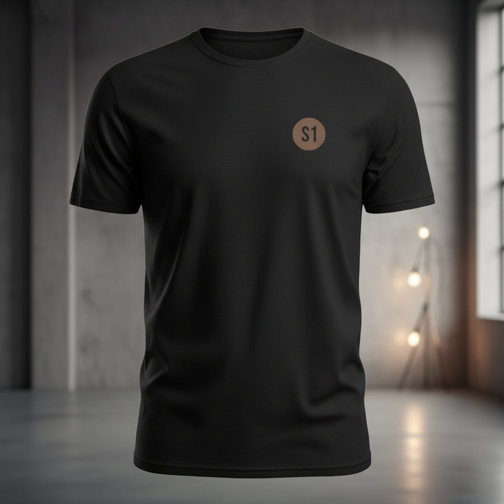 Vorderansicht des schwarzen Unisex T-Shirts im Regular Fit mit einem kleinen, orangefarbenen Status-1-Logo auf der linken Brust.