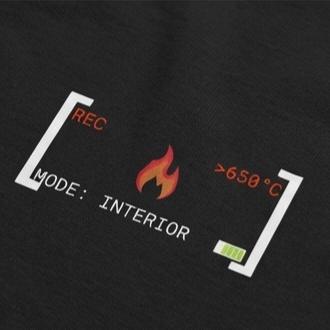 Nahaufnahme des weißen Brust-Aufdrucks im Stil einer Wärmebildkameraanzeige mit kleiner Flamme und der Aufschrift MODE: INTERIOR.