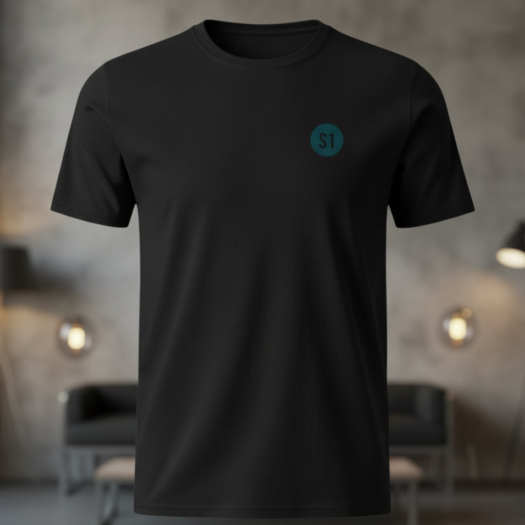Vorderansicht des schwarzen Unisex T-Shirts im Regular Fit mit einem kleinen, blauen Status-1-Logo auf der linken Brust.