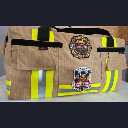 Upcycling-Feuerwehrtasche aus beiger Einsatzkleidung mit gelb-silbernen Reflektoren sowie Station 5 Baumholder und BMA Heroes Patches.