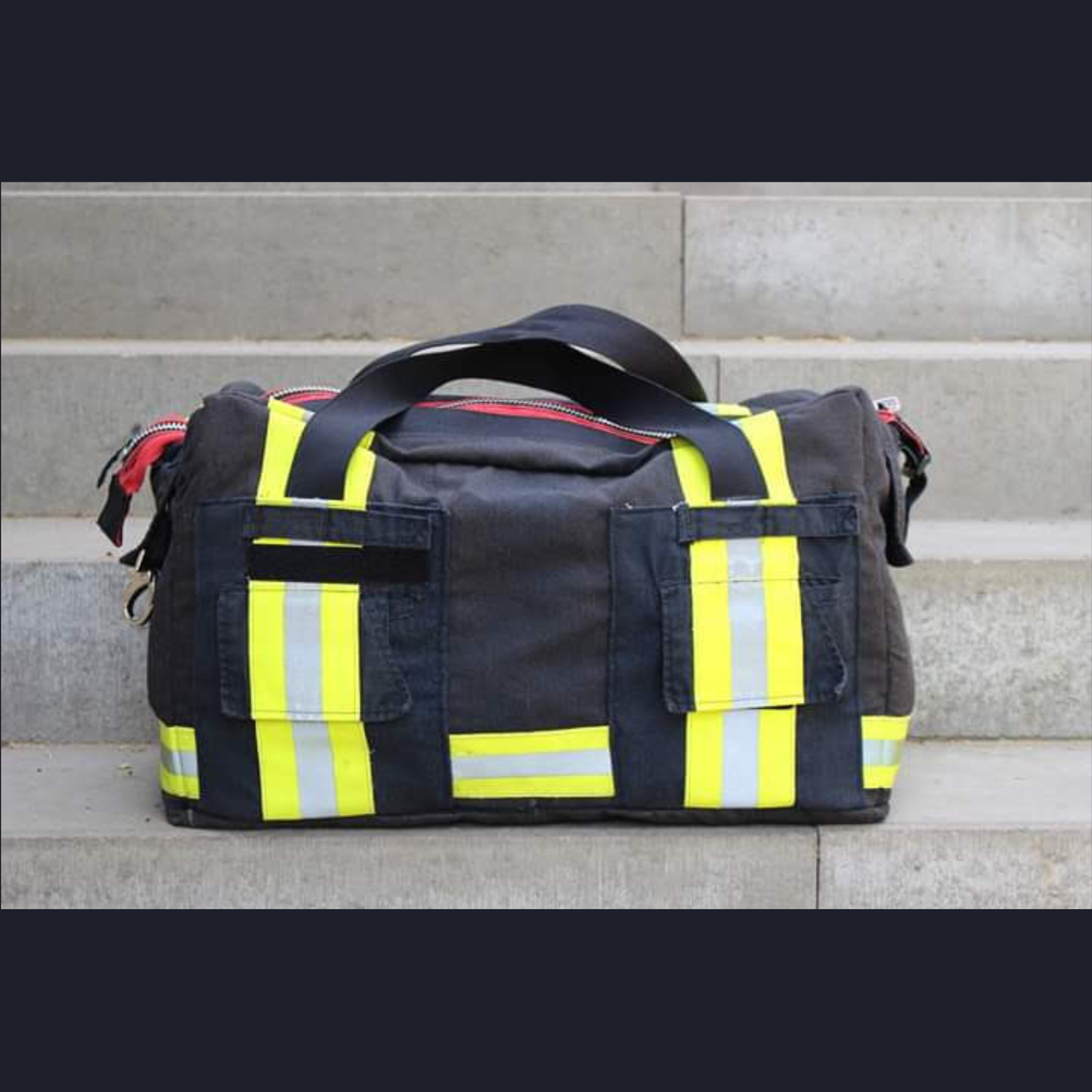 Upcycling-Feuerwehrtasche Rückansicht aus schwarzer Einsatzkleidung mit aufgesetzten Taschen.