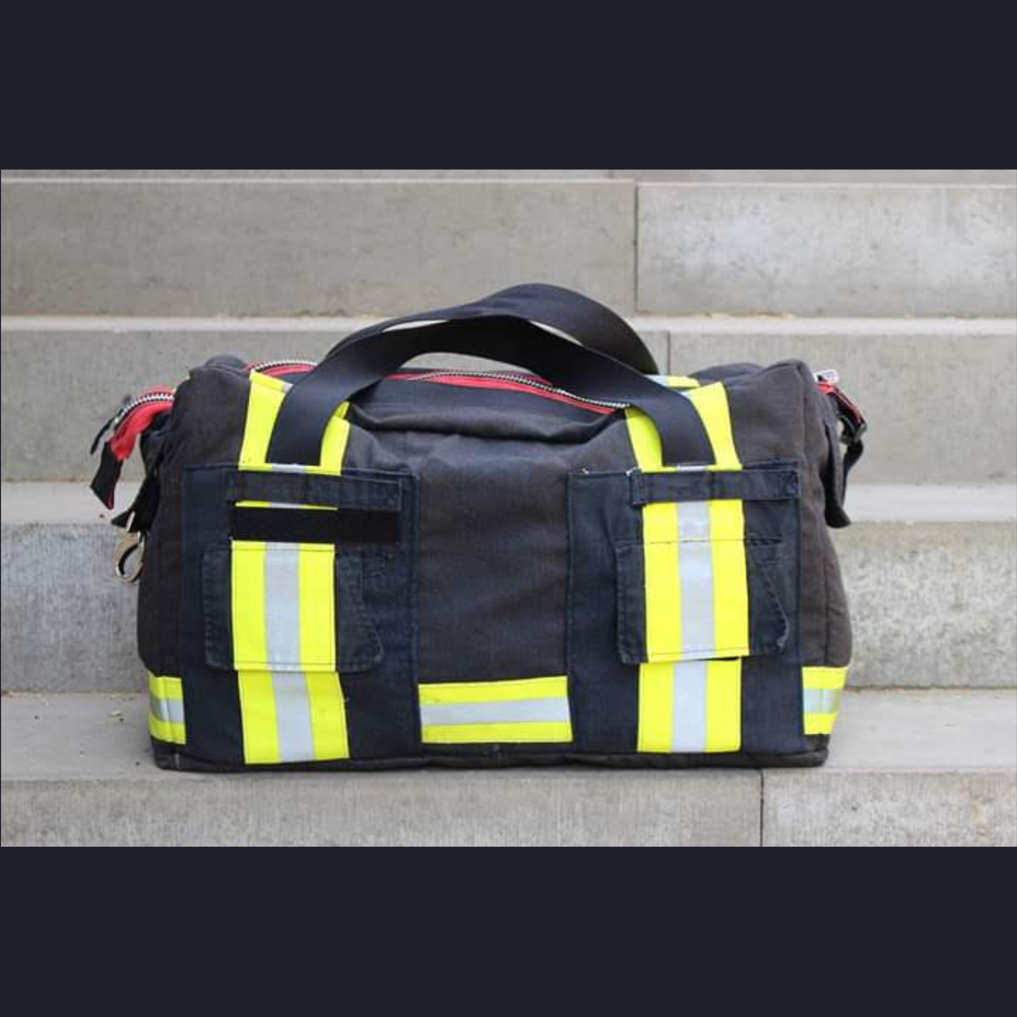 Upcycling-Feuerwehrtasche Rückansicht aus schwarzer Einsatzkleidung mit aufgesetzten Taschen.