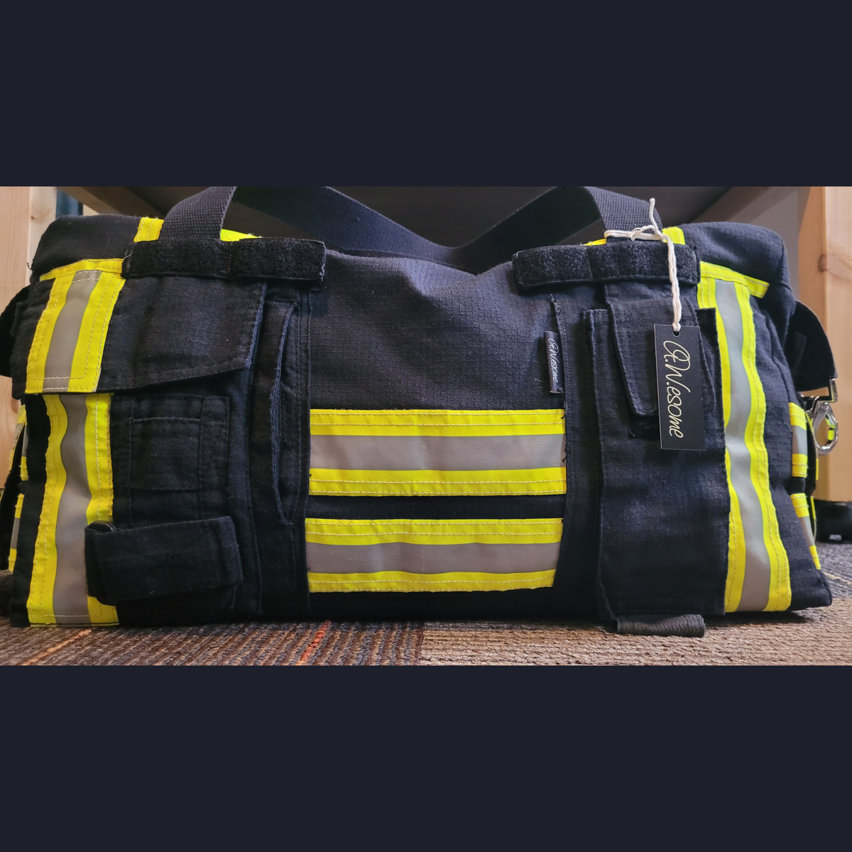 Upcycling-Feuerwehrtasche Rückansicht aus schwarzer Einsatzkleidung mit aufgesetzten Taschen.