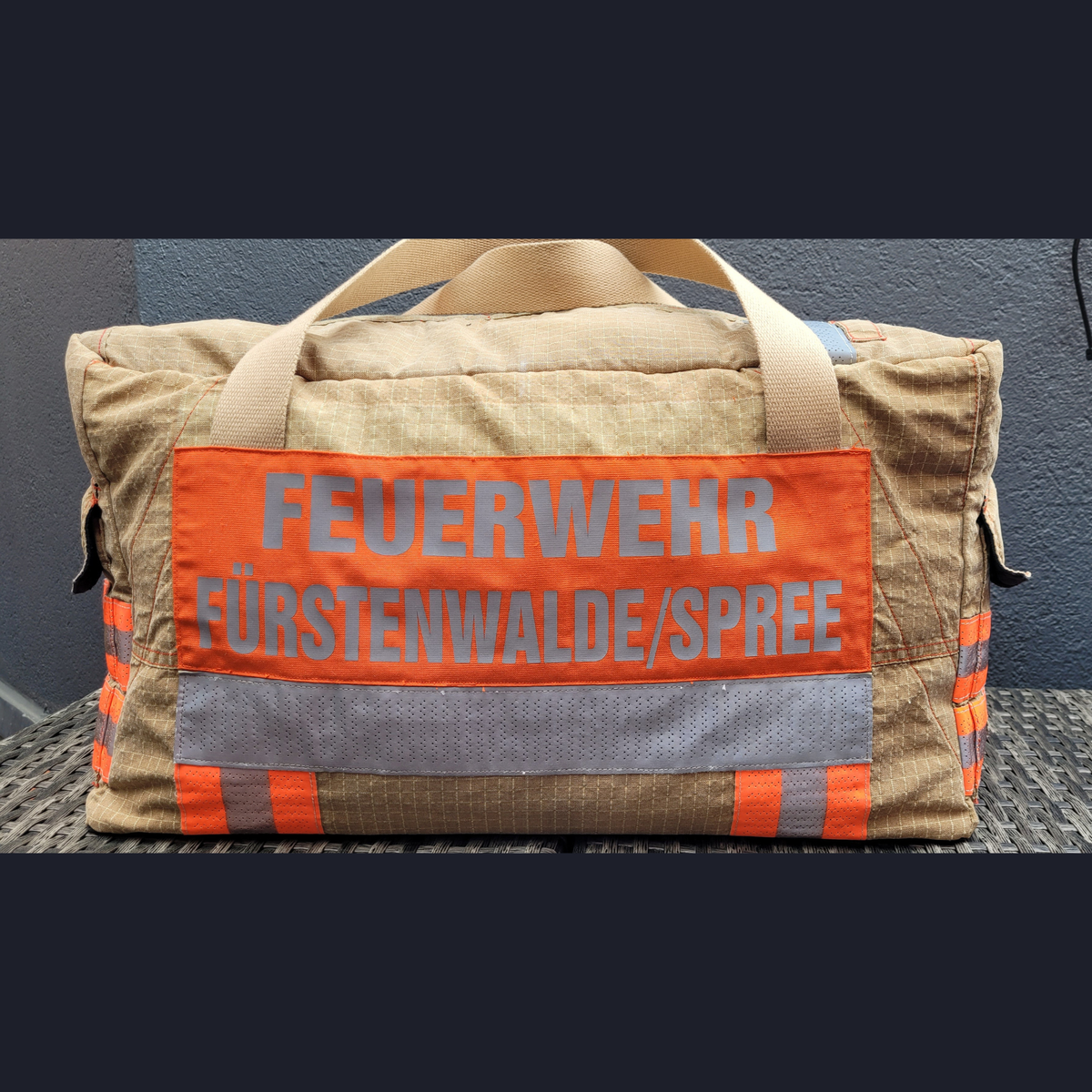 Upcycling-Feuerwehrtasche aus beiger Feuerwehrjacke mit orangefarbenem Rückenaufdruck FEUERWEHR FÜRSTENWALDE/SPREE.