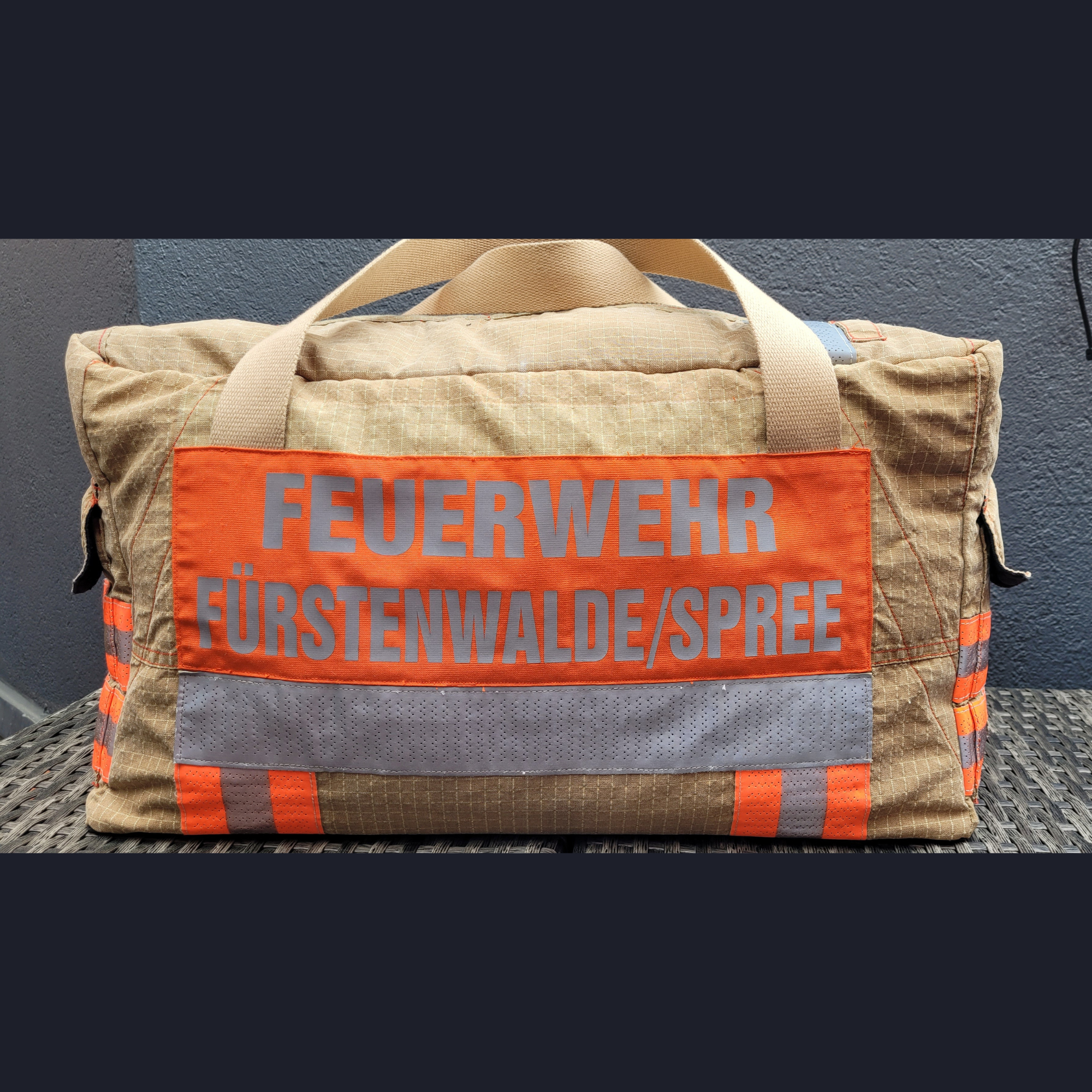 Upcycling-Feuerwehrtasche aus beiger Feuerwehrjacke mit orangefarbenem Rückenaufdruck FEUERWEHR FÜRSTENWALDE/SPREE.