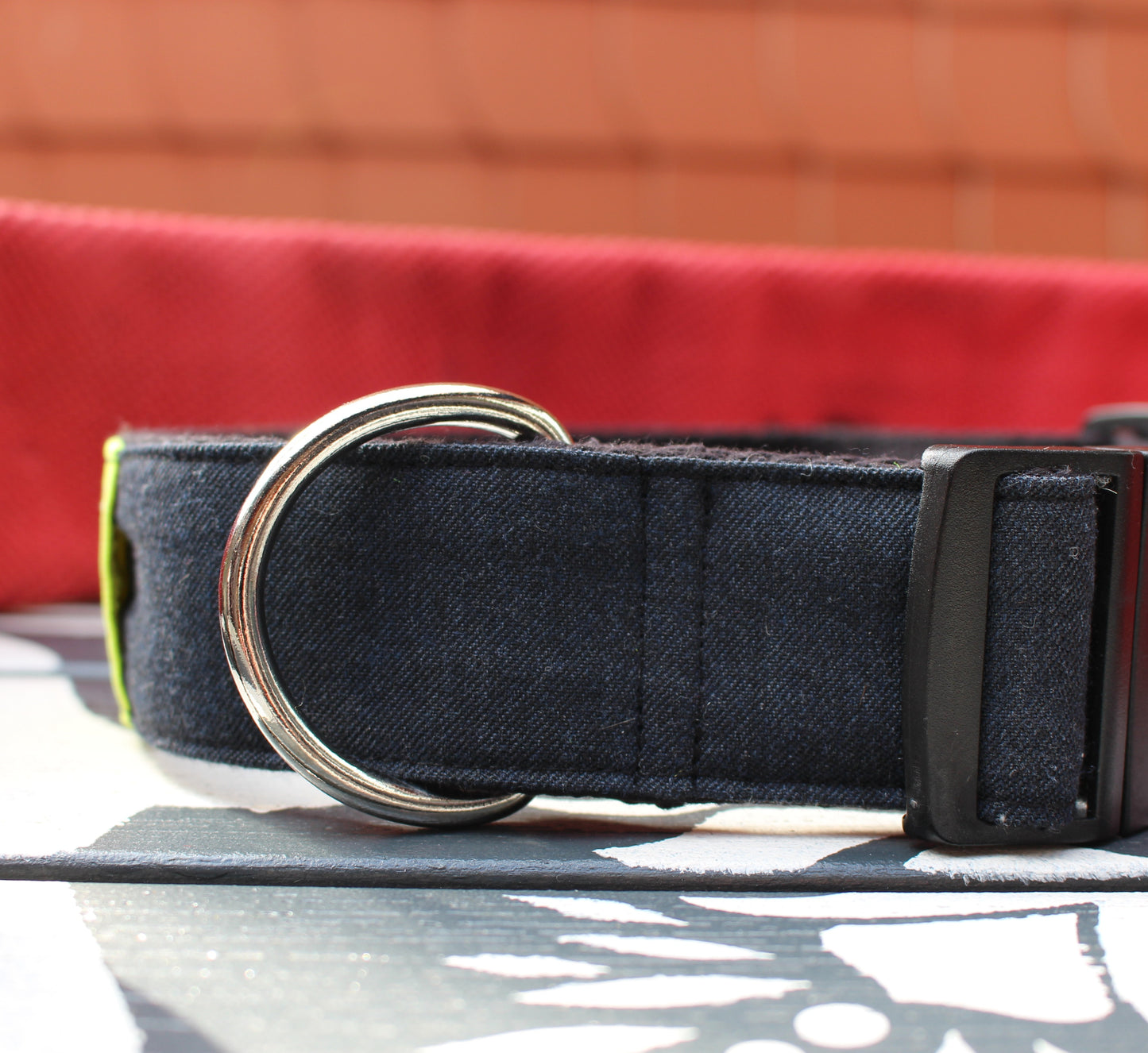 Produktfoto (roter Hintergrund, Seitenansicht) Blue Hero Hundehalsband Upcycling – Seitenansicht auf rotem Hintergrund, dunkelblau mit gelbem Reflexstreifen