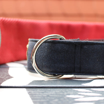 Nahaufnahme des robusten, silbernen D-Rings zur Leinenbefestigung am dunkelblauen Upcycling-Halsband vor rotem Hintergrund.