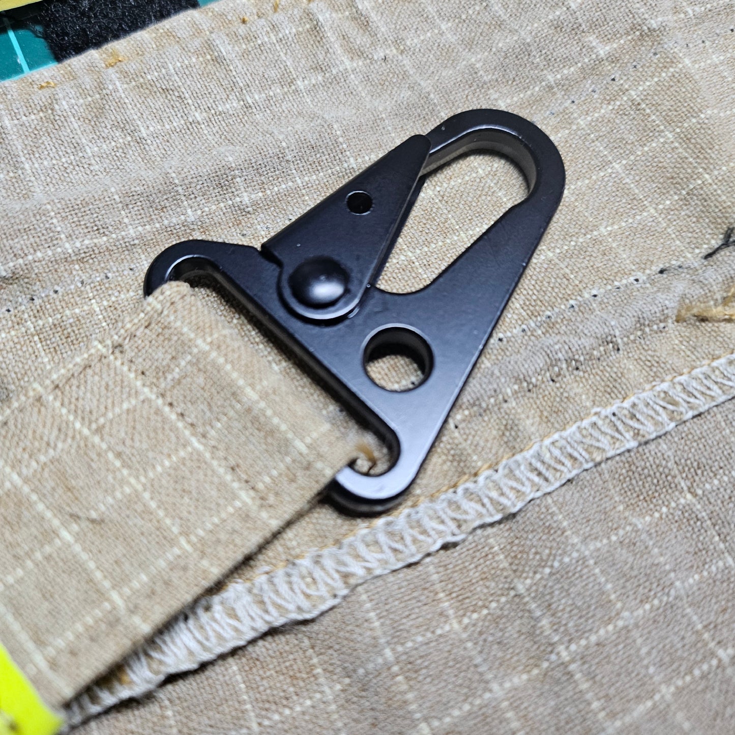 Karabiner aus Metall am sandfarbenen Feuerwehr-Handschuhhalter aus Aramid-Einsatzstoff – Nahaufnahme der stabilen Befestigungsmechanik für die TH"