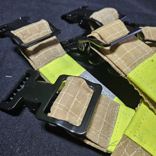 "Draufsicht auf mehrere sandfarben-karierte Feuerwehr-Handschuhhalter mit neongelben Reflexstreifen und schwarzen Metallschnallen aus Aramid-Einsatzstoff"

