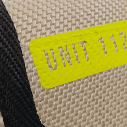 "Nahaufnahme des neongelben UNIT 112 Flexfolien-Prints auf weißem Feuerwehrschlauch-Gewebe der Upcycling Meldertasche – hochwertige Veredelung im Detail"
