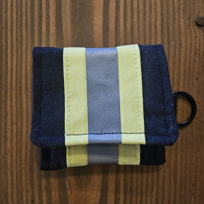 "Feuerwehr Mini-Notfall-Tasche dunkelblau mit gelbem Reflexstreifen – geöffnet auf Holzuntergrund, Klettverschluss sichtbar"


