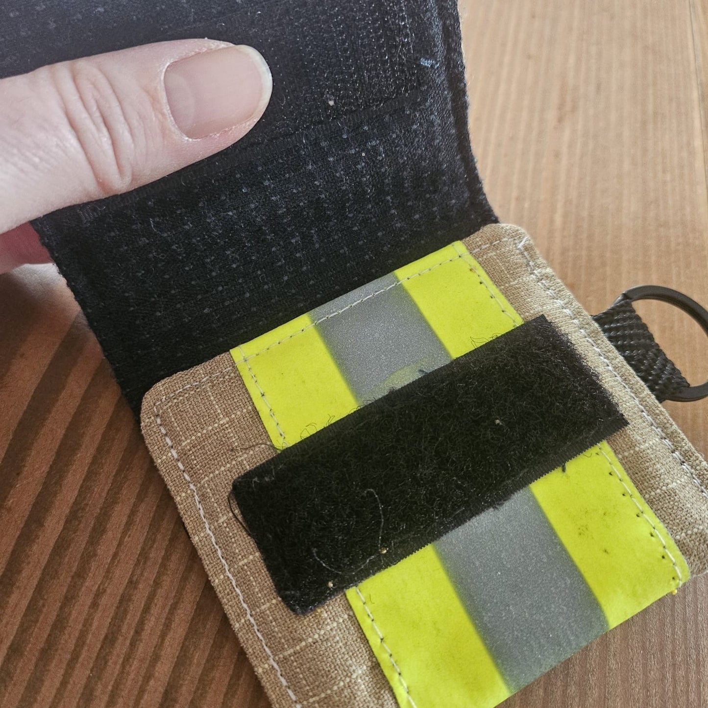 "Feuerwehr Mini-Notfall-Tasche sandfarben geöffnet – schwarzer Klettverschluss und gelber Reflexstreifen innen sichtbar, D-Ring seitlich"

