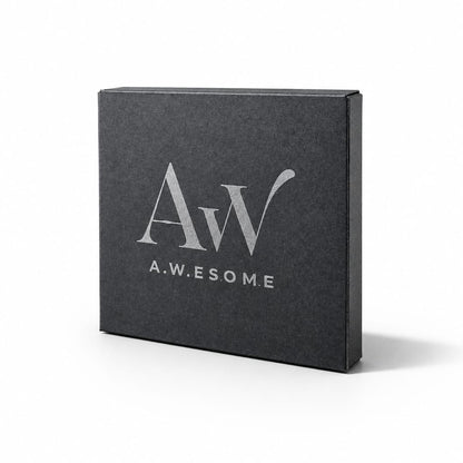 Eine geschlossene, quadratische Geschenkbox aus mattschwarzem Karton vor weißem Hintergrund mit dem silbernen Logo „Aw“ und dem Markennamen „A.W.E.SOME“ auf der Vorderseite.
