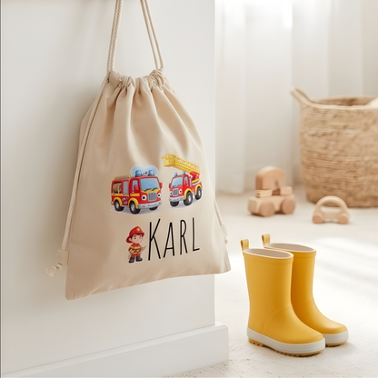 Beutel für Wechselkleidung mit Feuerwehr-Motiv hängt an einer Wand über gelben Kinder-Gummistiefeln im Flur.